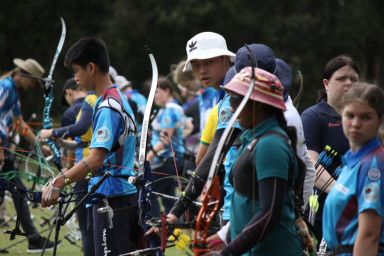 A group of youth archers at a competition getting ready to shoot